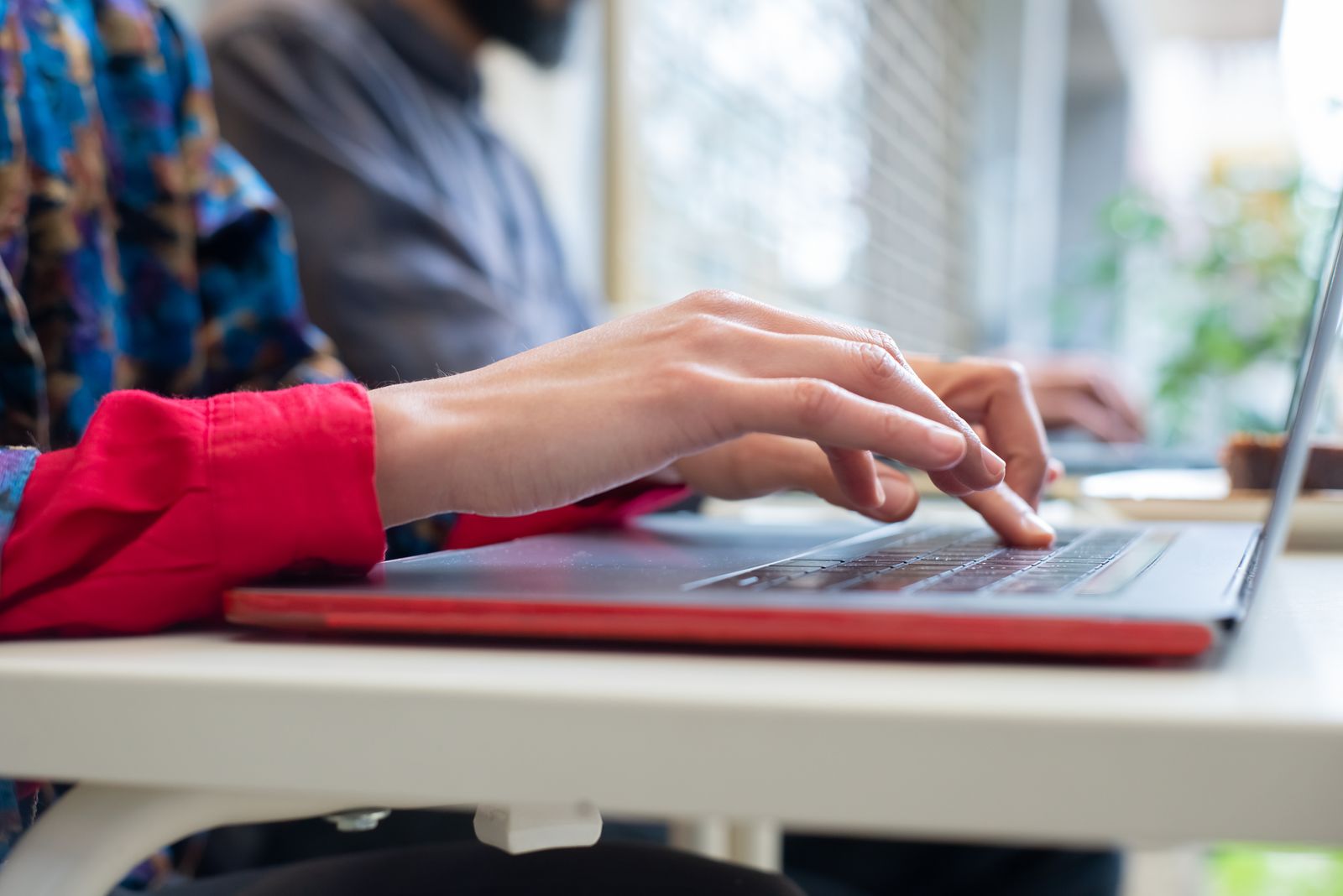 Close-up of hands typing on a laptop
